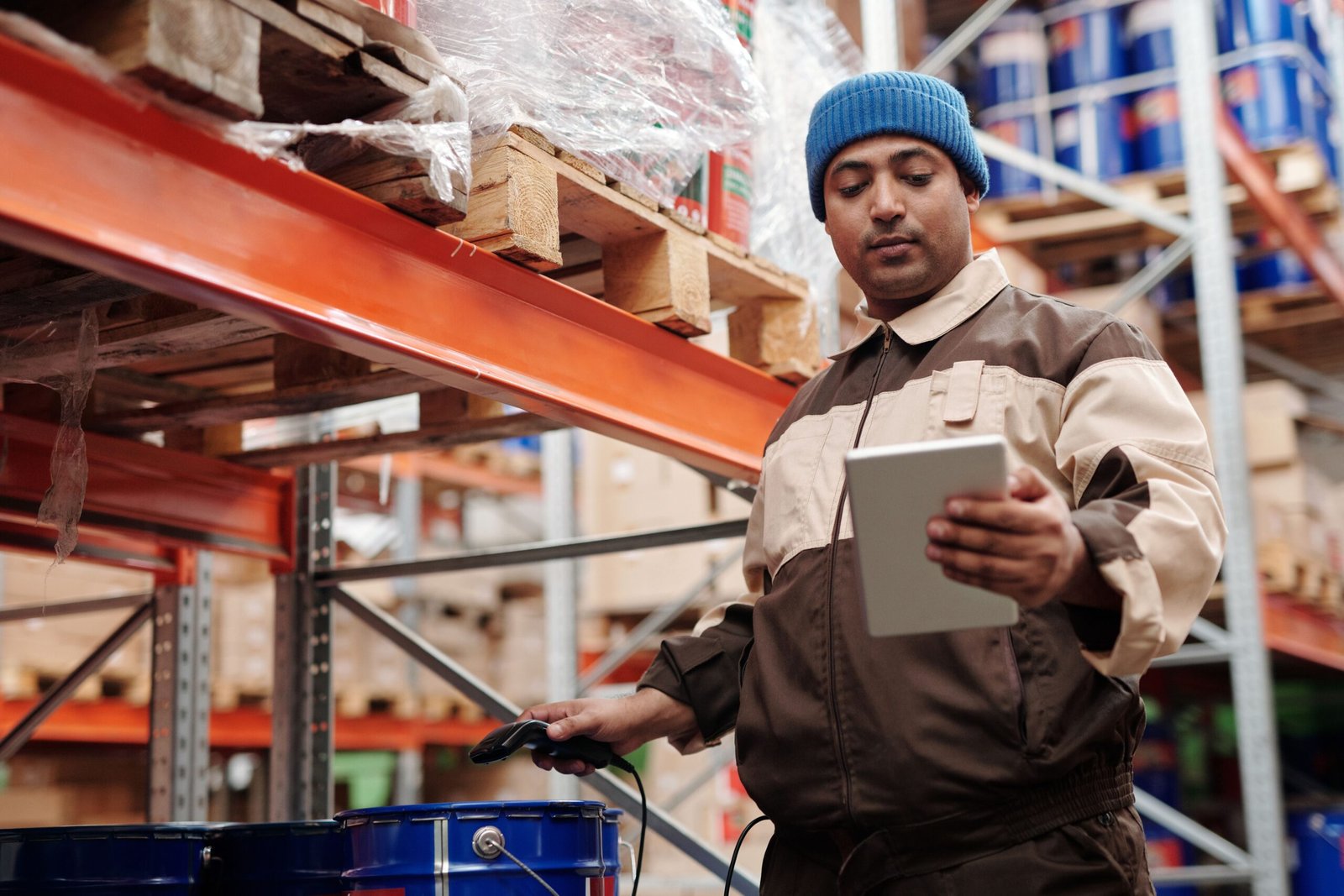 Warehouse worker checking inventory with a tablet and barcode scanner